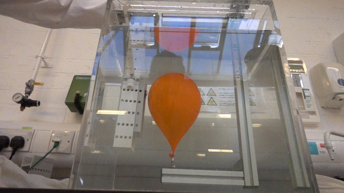 An orange balloon submerged in the balloon-burst tank